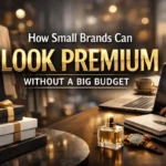 Luxury-themed workspace with gift boxes, perfume bottle, watch, laptop, and elegant boutique background, featuring text “How Small Brands Can Look Premium Without a Big Budget.”